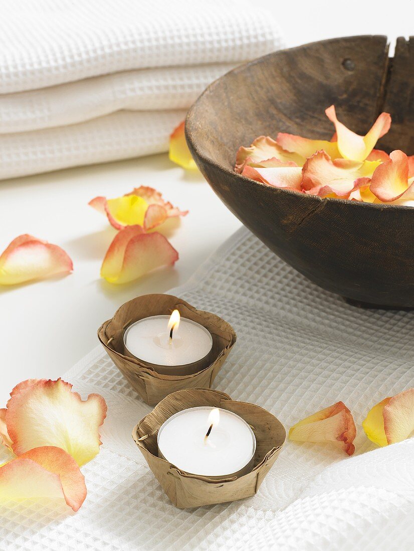 Rose petals in a wooden bowl and tealights