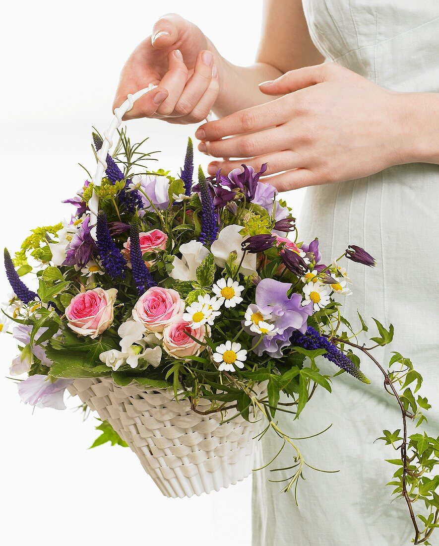 Frau hält Blumenkorb mit Rosen