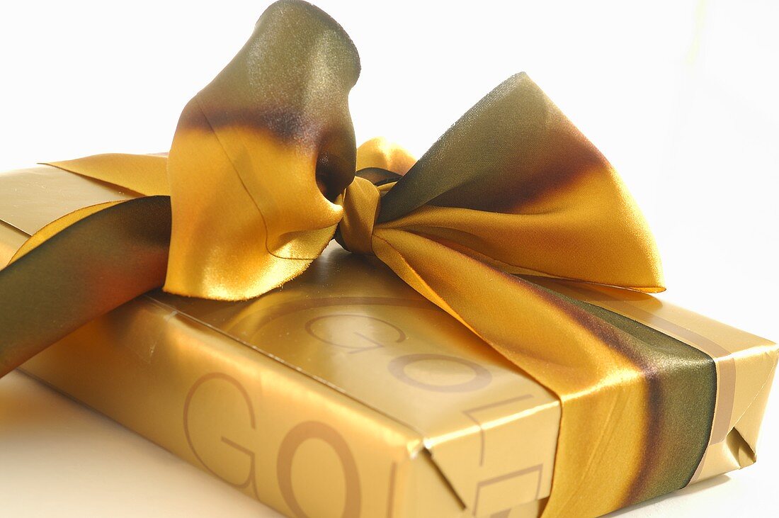 Gift wrapped in gold paper with bow