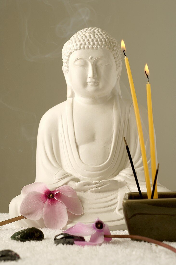 Buddha with cyclamen flowers, candles, joss sticks & hematite