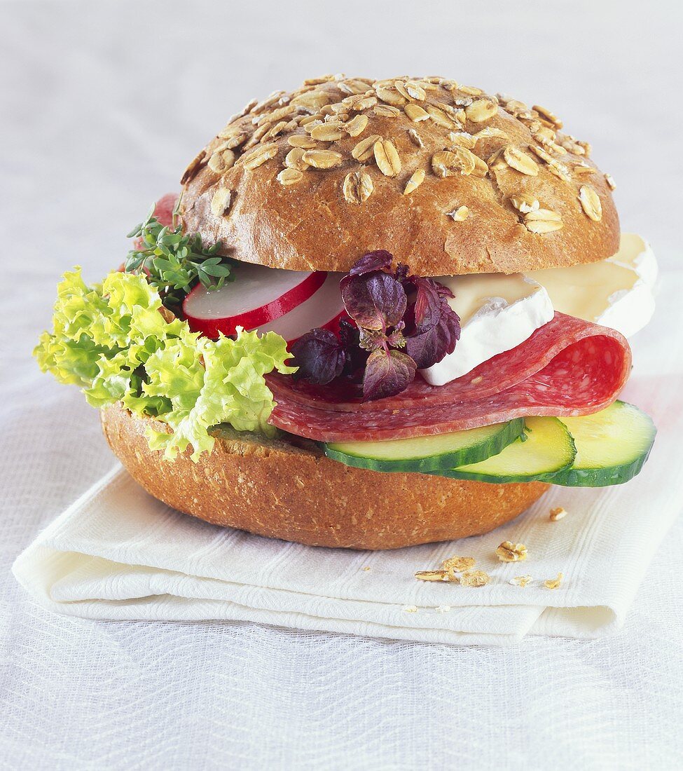 Oat roll filled with salami, Brie and salad