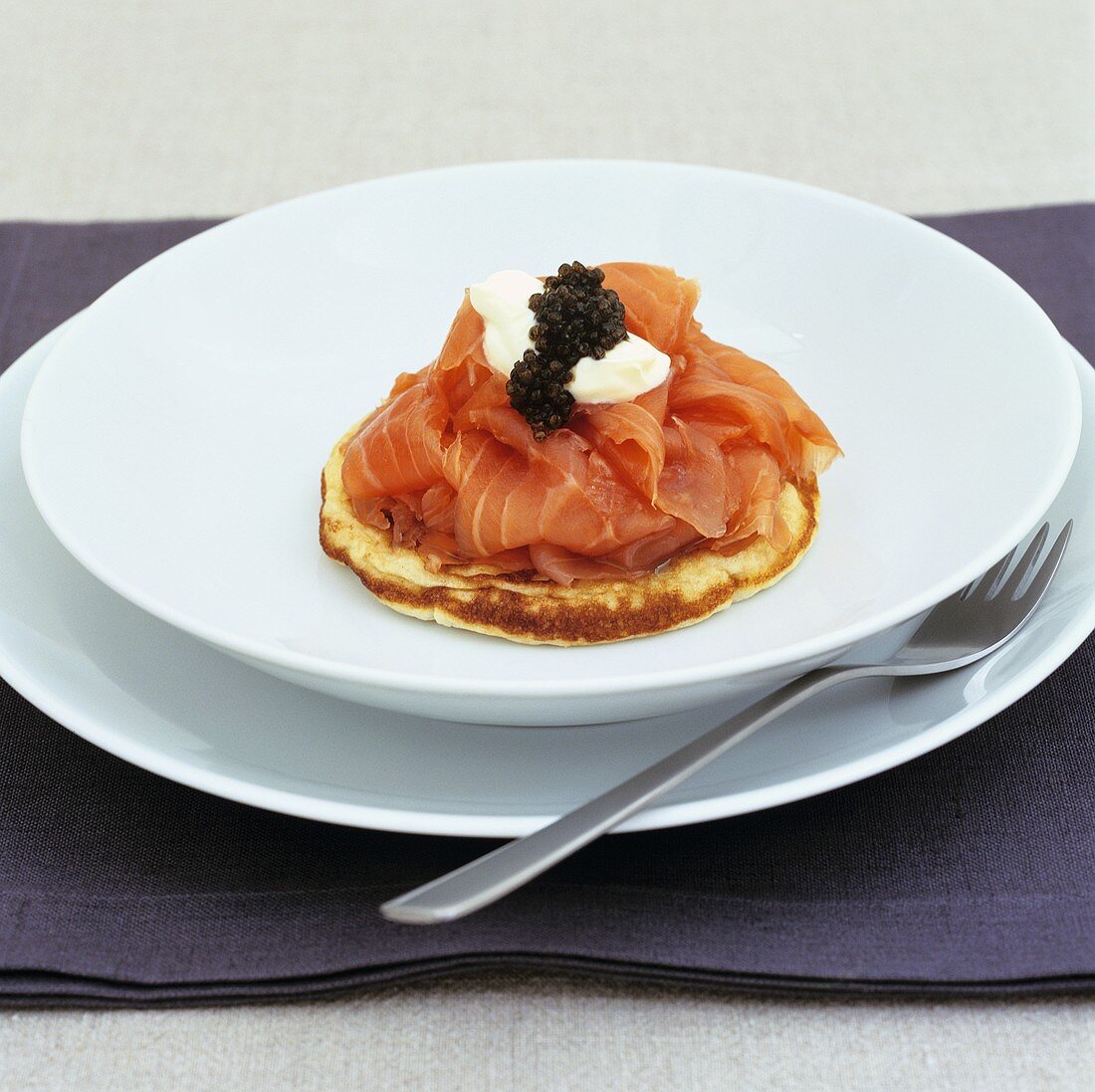 Smoked salmon with sour cream and caviar on blini