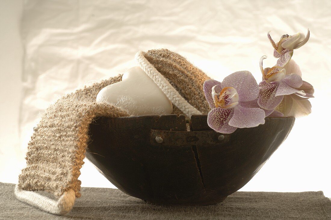 Back strap massager, heart-shaped soap, orchids in wooden bowl