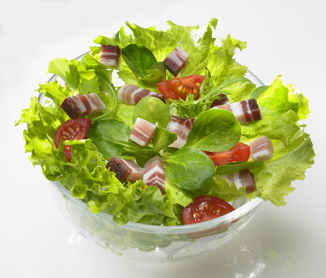 Grüner Salat mit Speckwürfeln und Tomaten