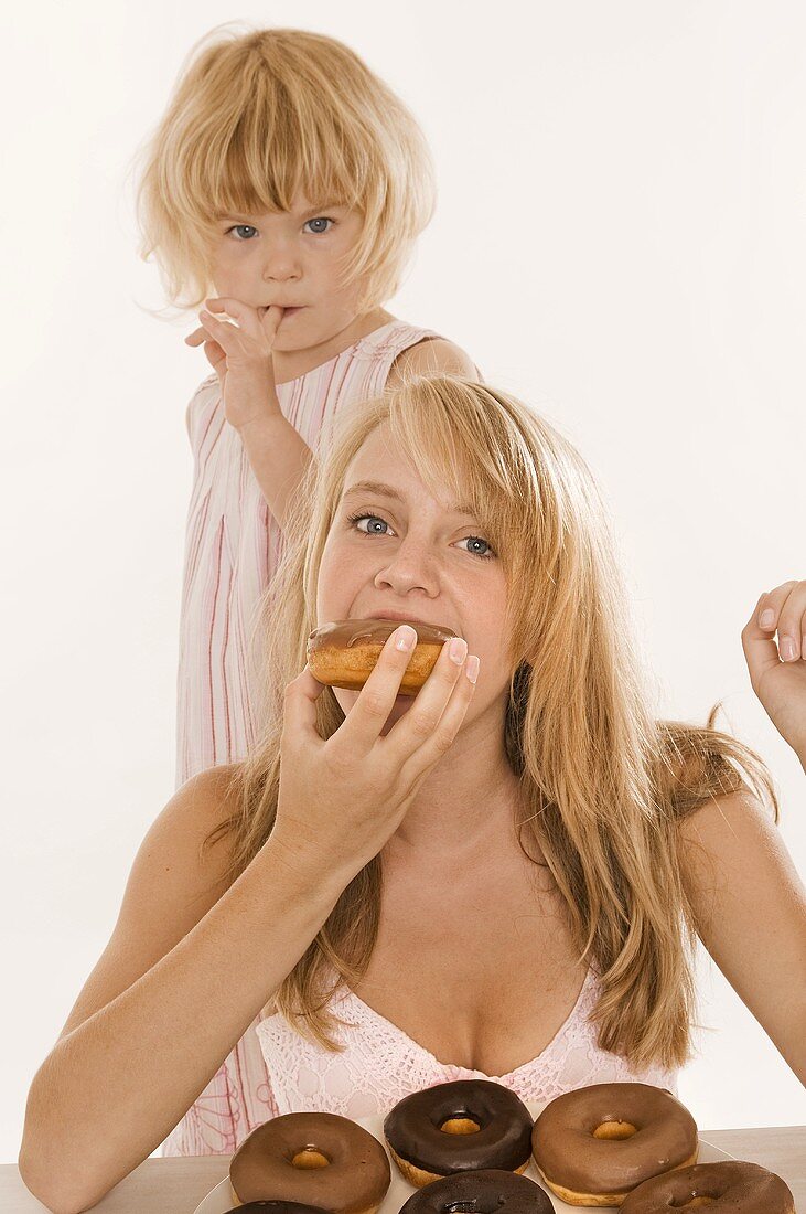 Two girls eating doughnuts