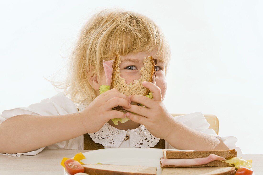 Kleines Mädchen mit belegtem Brot