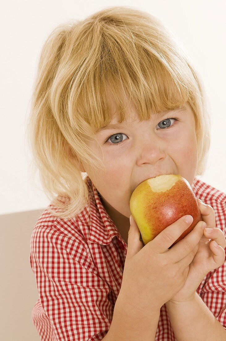 Little girl eating an organic apple