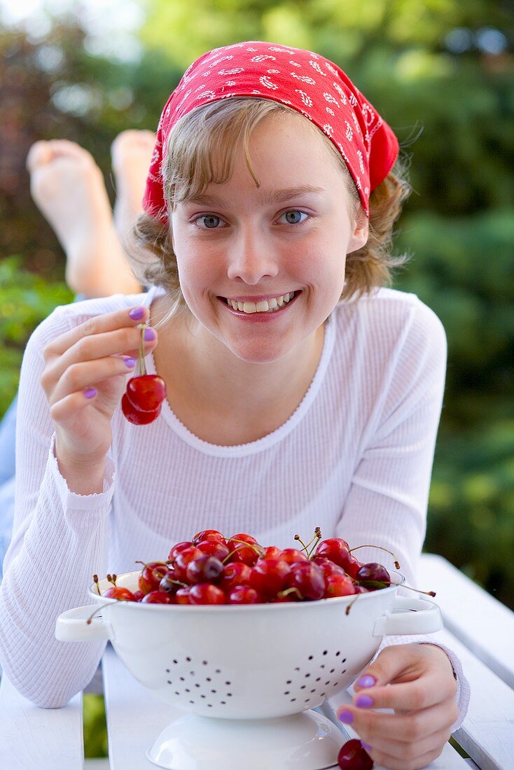 Girl with cherries in garden