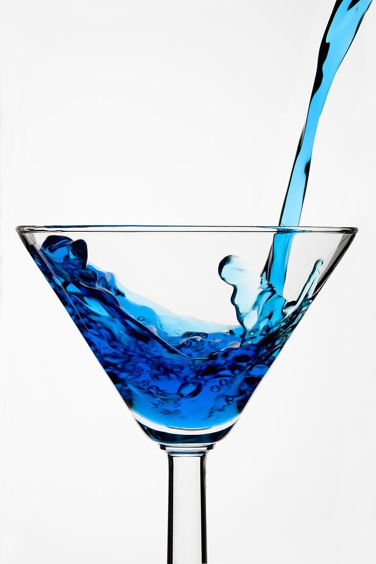 Pouring Blue Curaçao into a glass