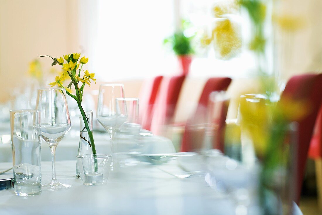 Gedeckter Tisch mit Gläsern und Blumen in einem Restaurant