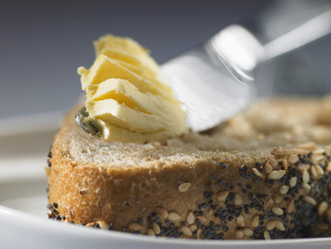 Butter knife with butter on seed bread