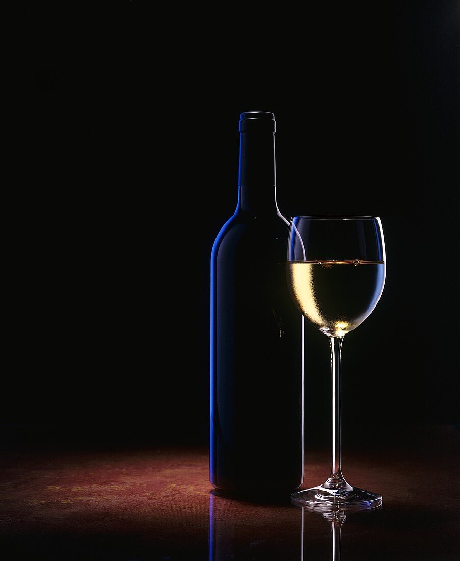 Ein Glas Weißwein und eine Weinflasche