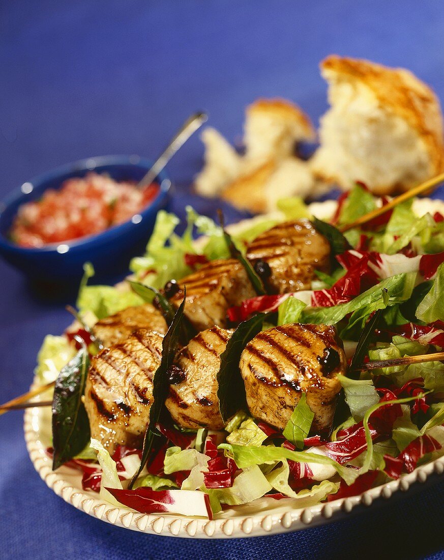 Grilled scallop kebabs on a bed of salad