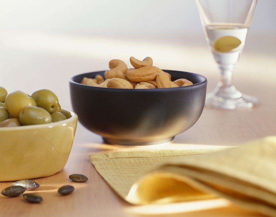 Olives, cashews and Martini with an olive