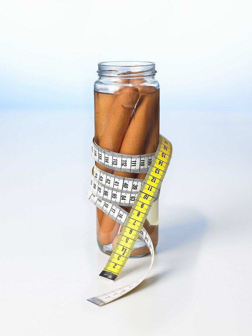 Frankfurters in a jar with a tape measure wrapped around it