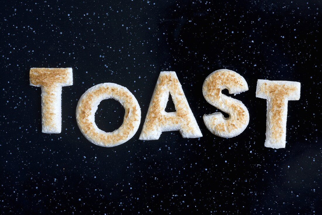Toast letters spelling the word TOAST on black background