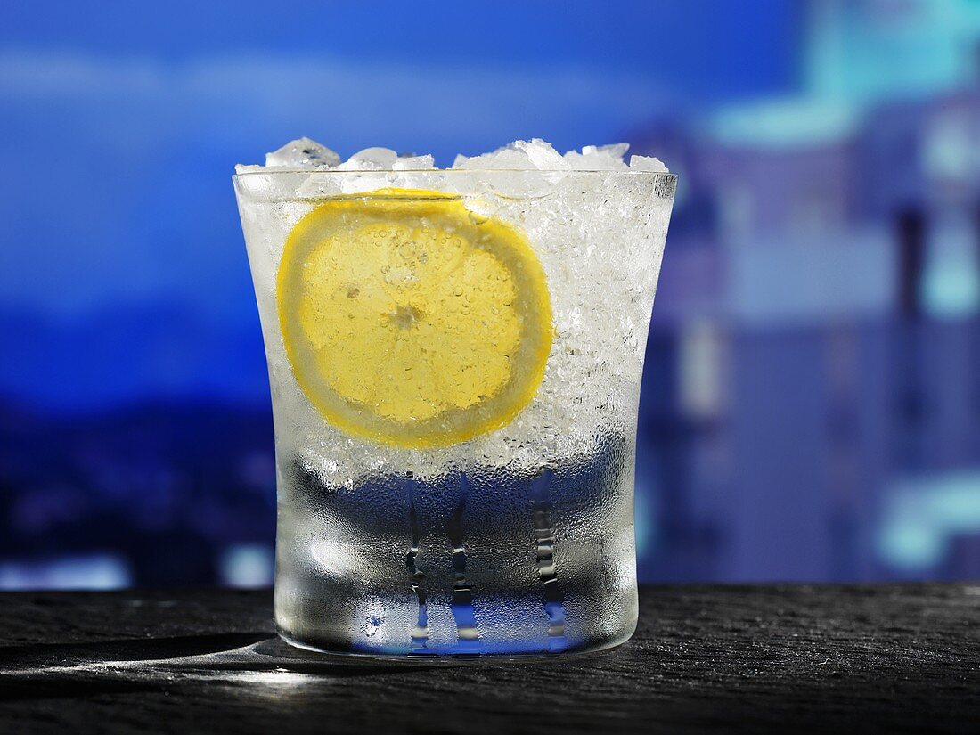 Glas Wasser mit Zitronenscheibe und Crushed Ice