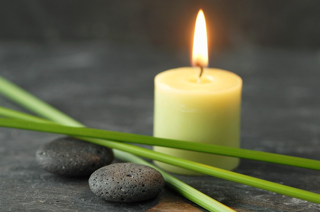 A candle, pebbles and papryus sedge