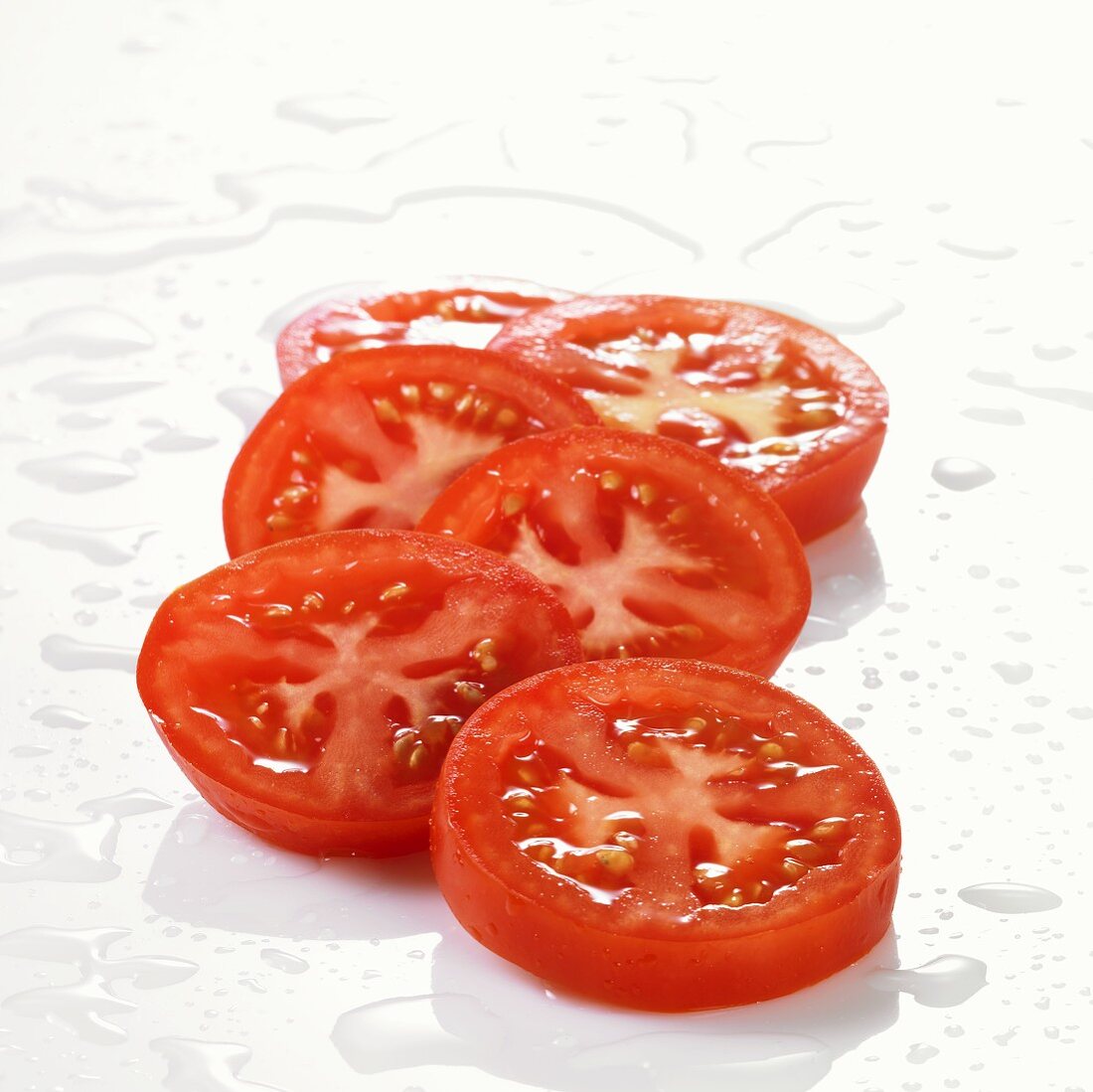 Mehrere Tomatenscheiben mit Wassertropfen