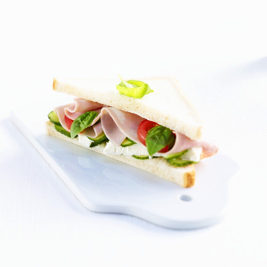 A ham, Camembert, tomato, cucumber and basil sandwich