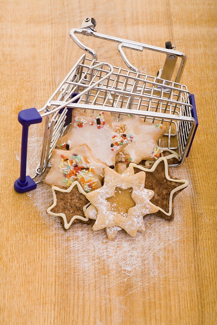Various Christmas biscuits in a mini shopping trolley