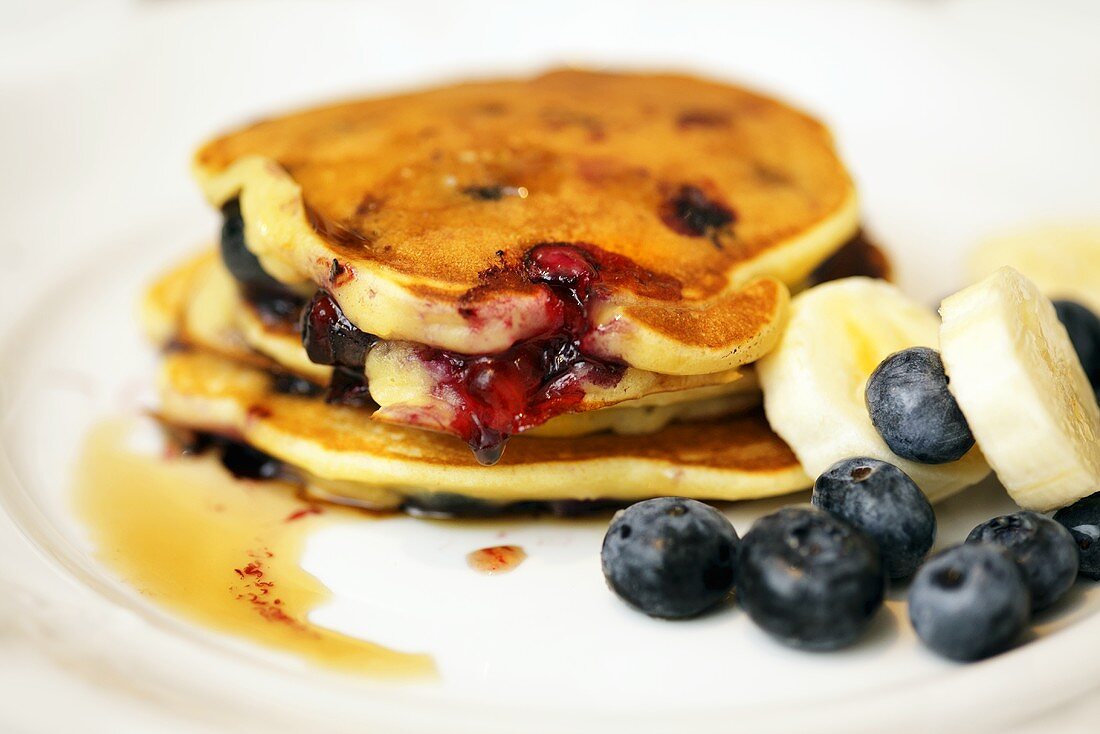 Pancakes with blueberries, bananas and maple syrup