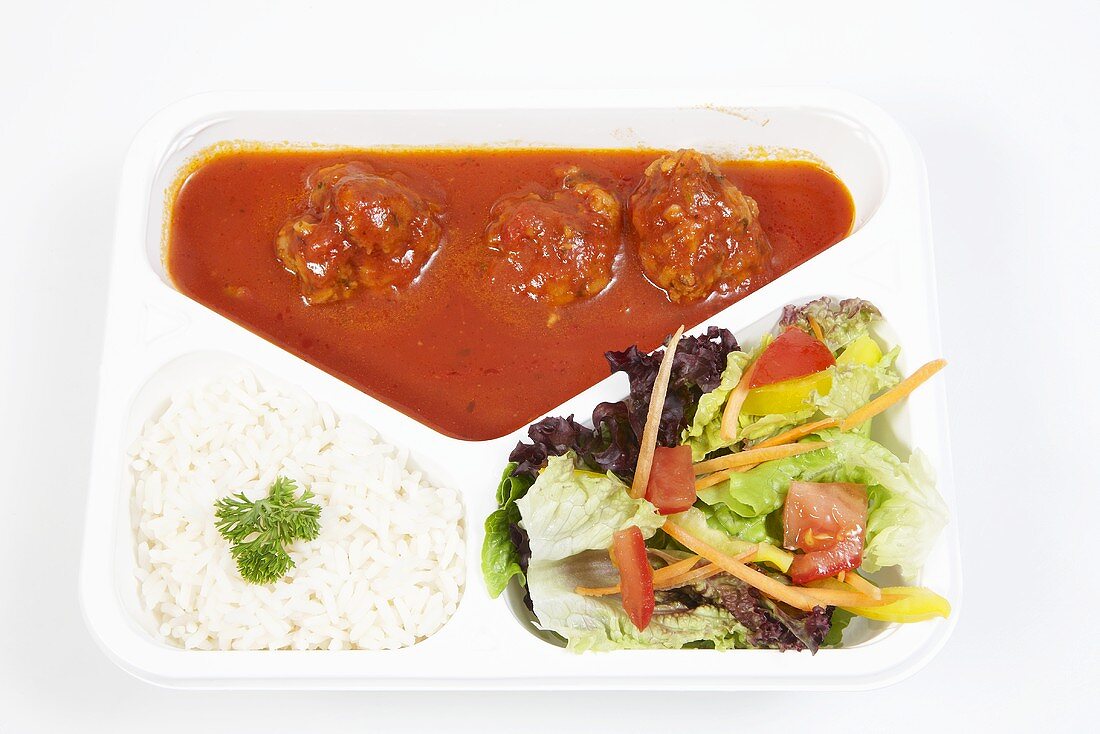 Meat balls in tomato sauce with rice and a mixed leaf salad