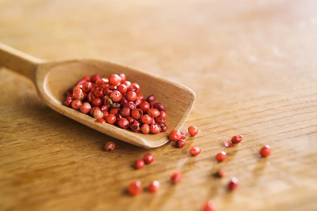 Pink pepper on a wooden scoop