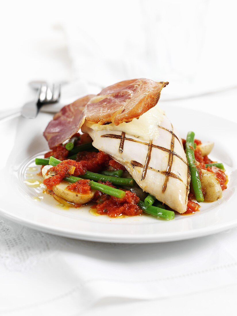Chicken breast with Parma ham on green beans and tomatoes