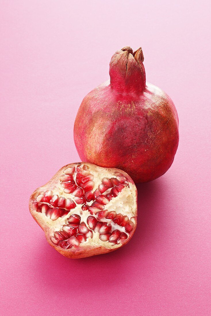 Whole pomegranate and half a pomegranate