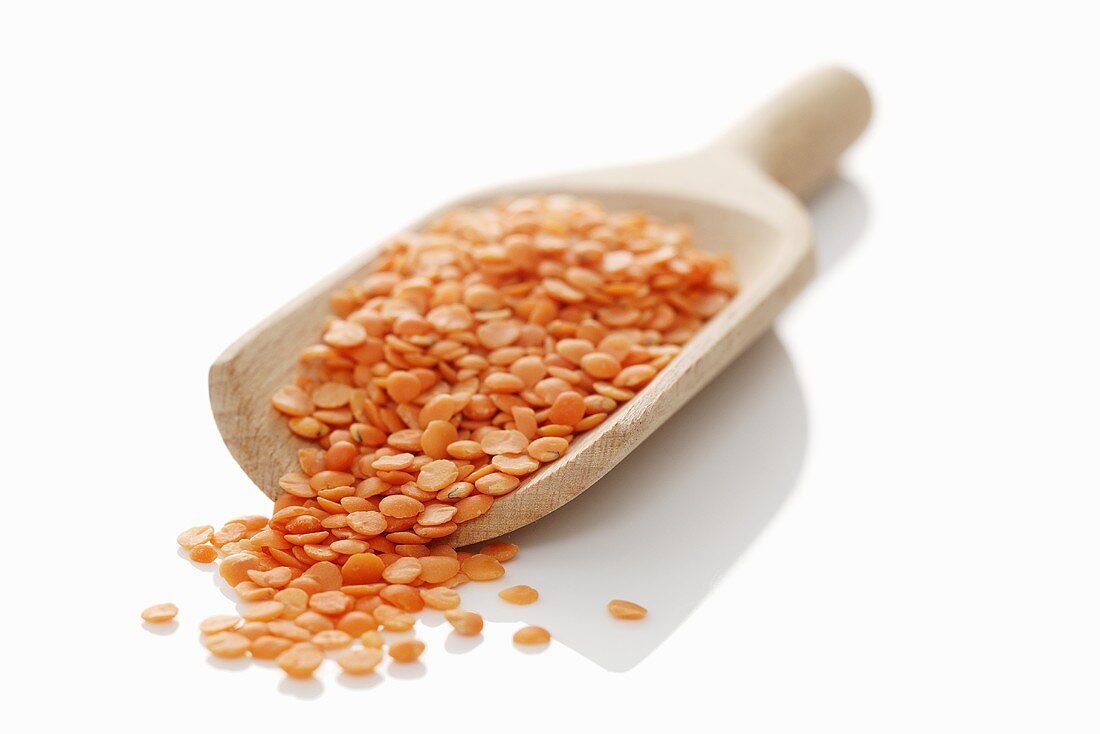 Red lentils in wooden scoop