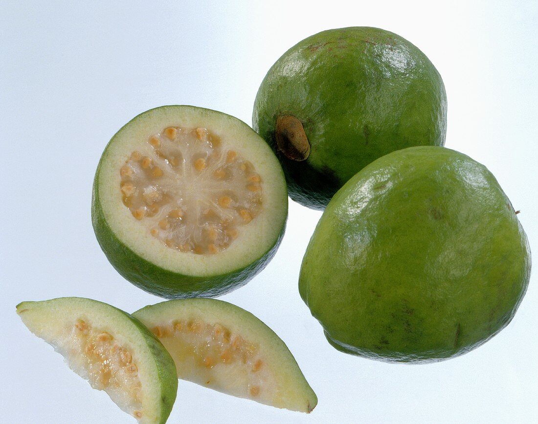 Two whole guavas and one cut open