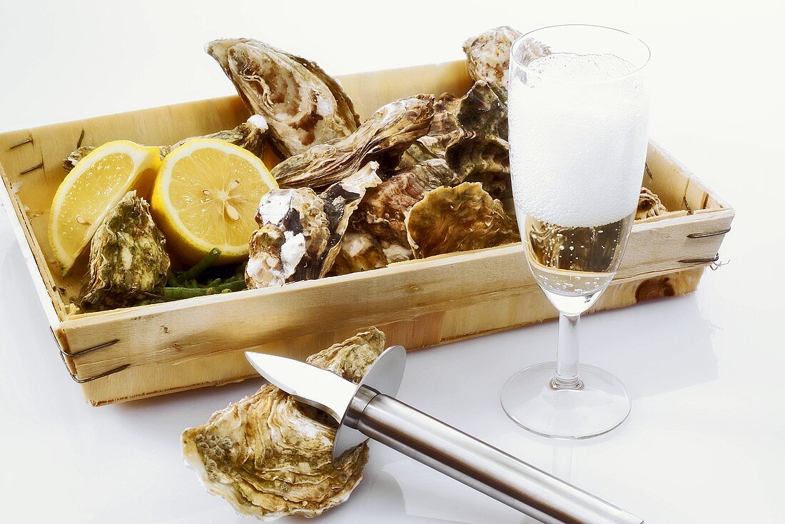 Frische Austern in einem Kistchen mit einem Glas Champagner