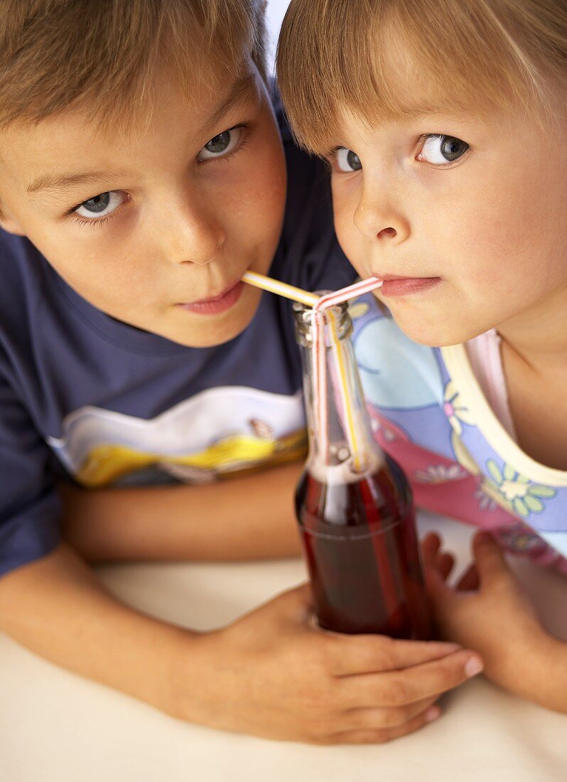 Kinder trinken Limonade mit Strohalm