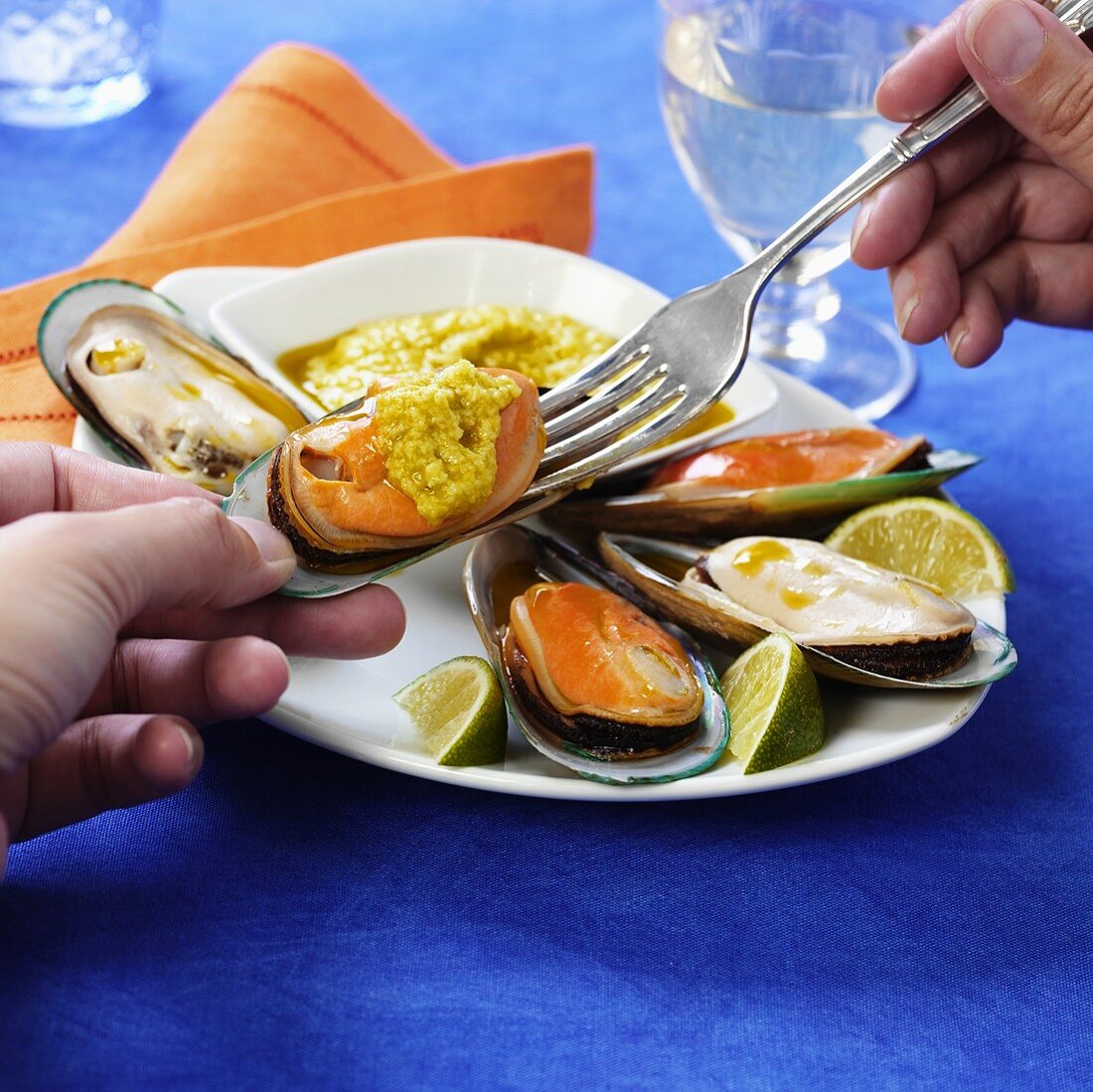 Taking mussels and dip out of shell with a fork