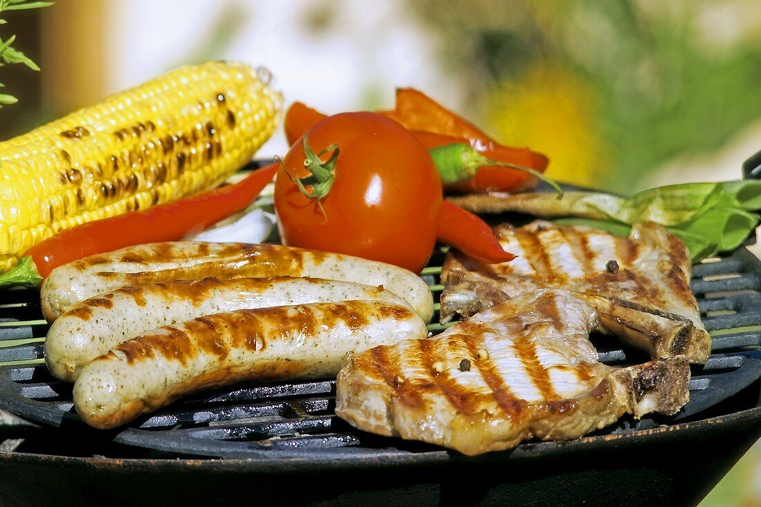 Sausages, chops and vegetables on a barbecue