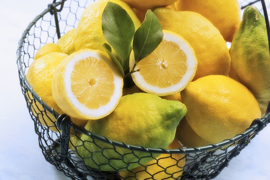 Organic lemons in a wire basket, one halved