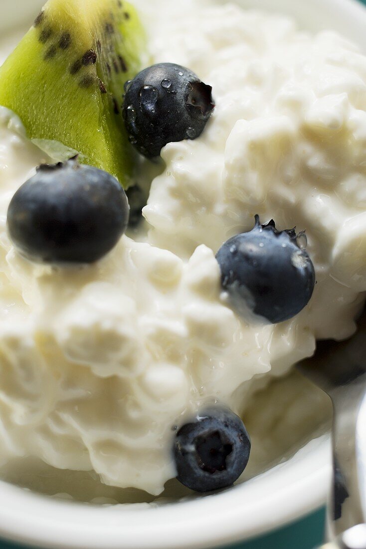 Hüttenkäse mit Heidelbeeren und Kiwi in einem Schälchen