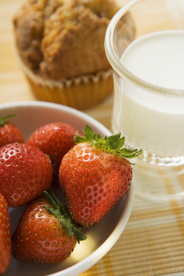 Strawberries, glass of milk and muffin for breakfast