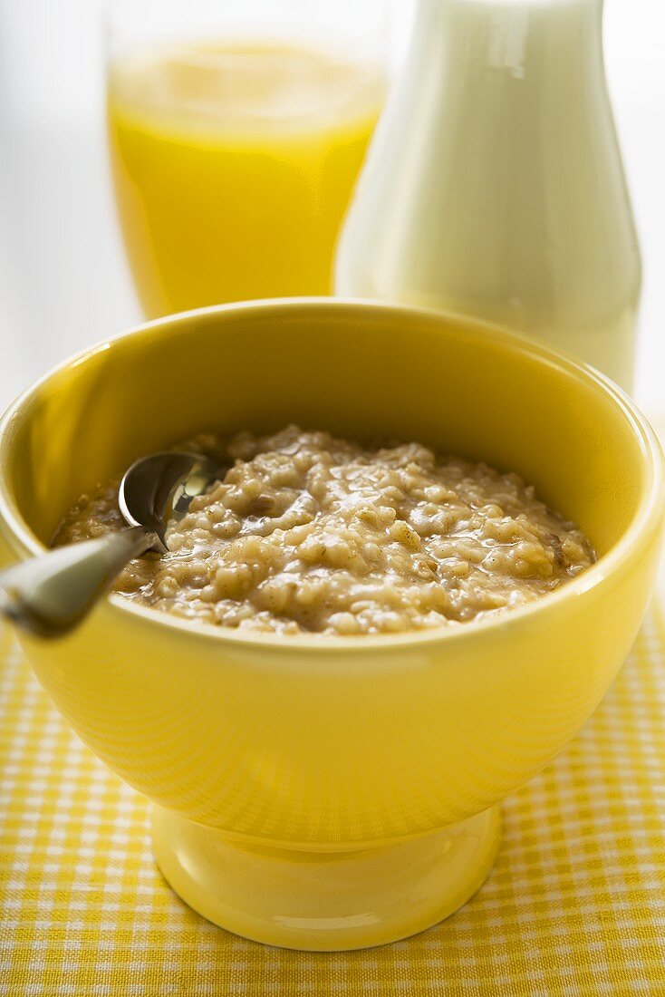 Porridge (Haferbrei), dahinter Milch und Orangensaft