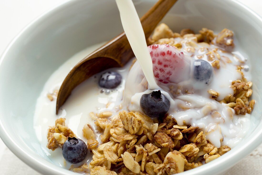 Knuspermüsli und Beeren mit Milch begiessen