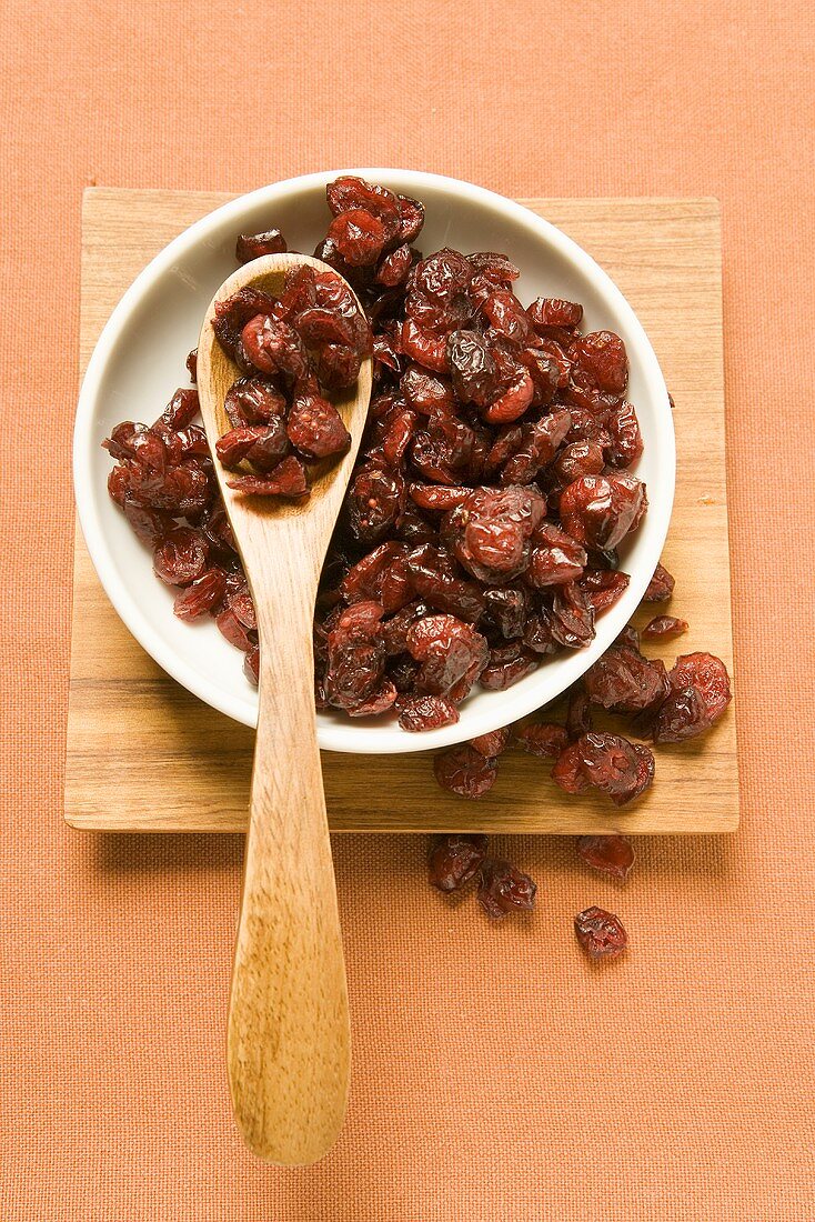 Cranberries in a bowl with wooden spoon