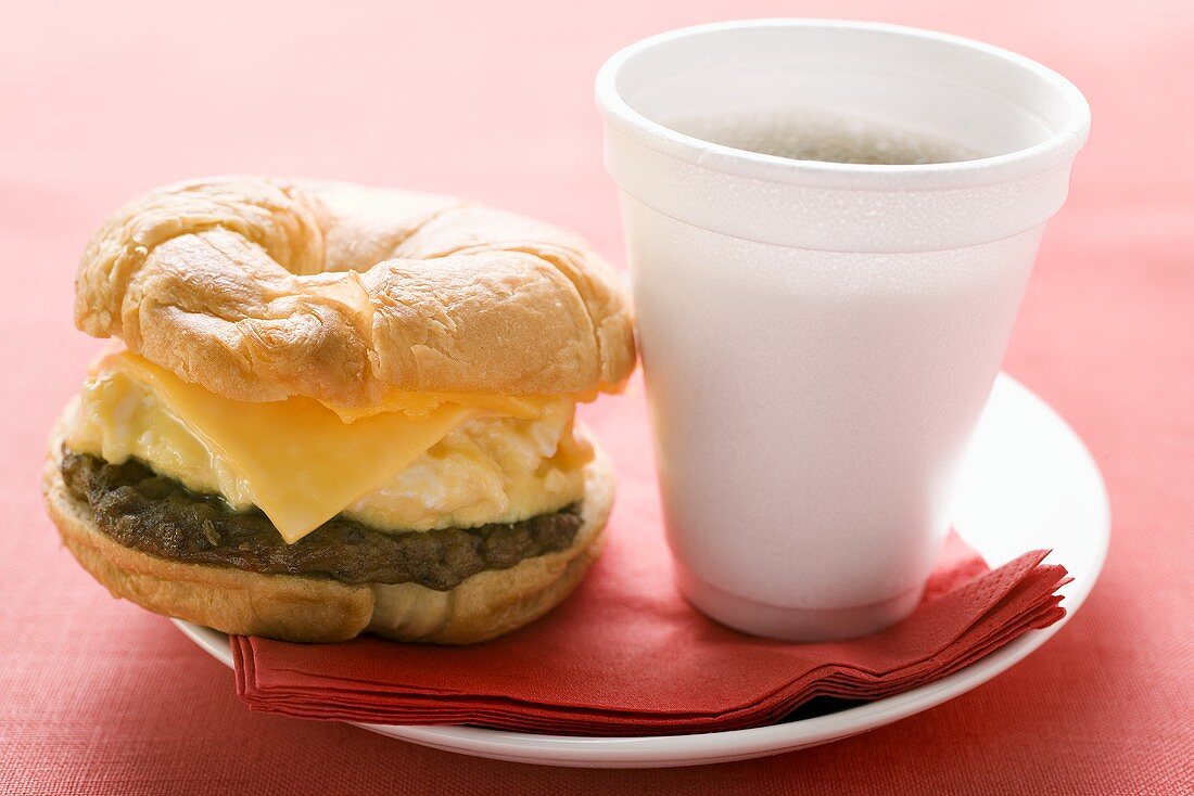 Cheeseburger with scrambled egg and a cup of coffee