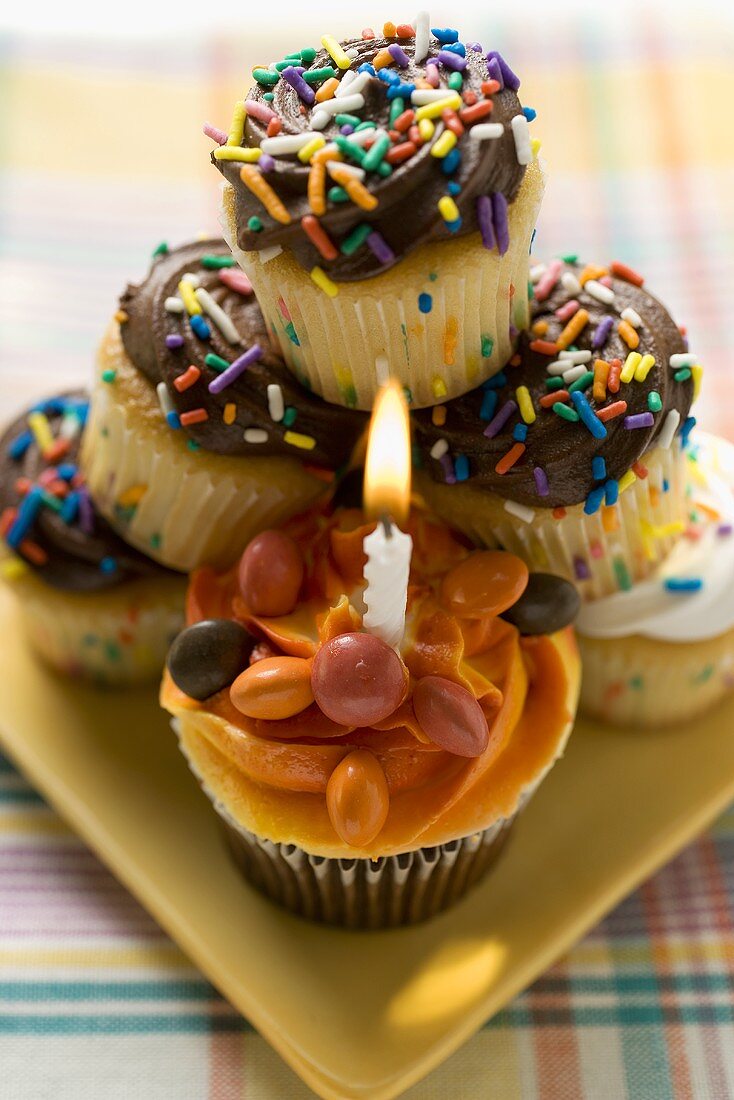 Assorted muffins, one with birthday candle