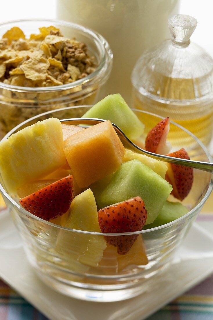Obstsalat, Cerealien und Honig für ein gesundes Frühstück