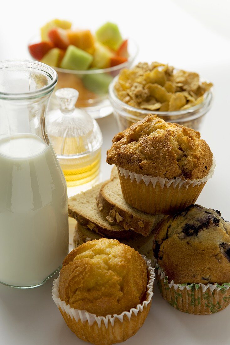 Brunch with baked products, muesli, fruit, milk and honey