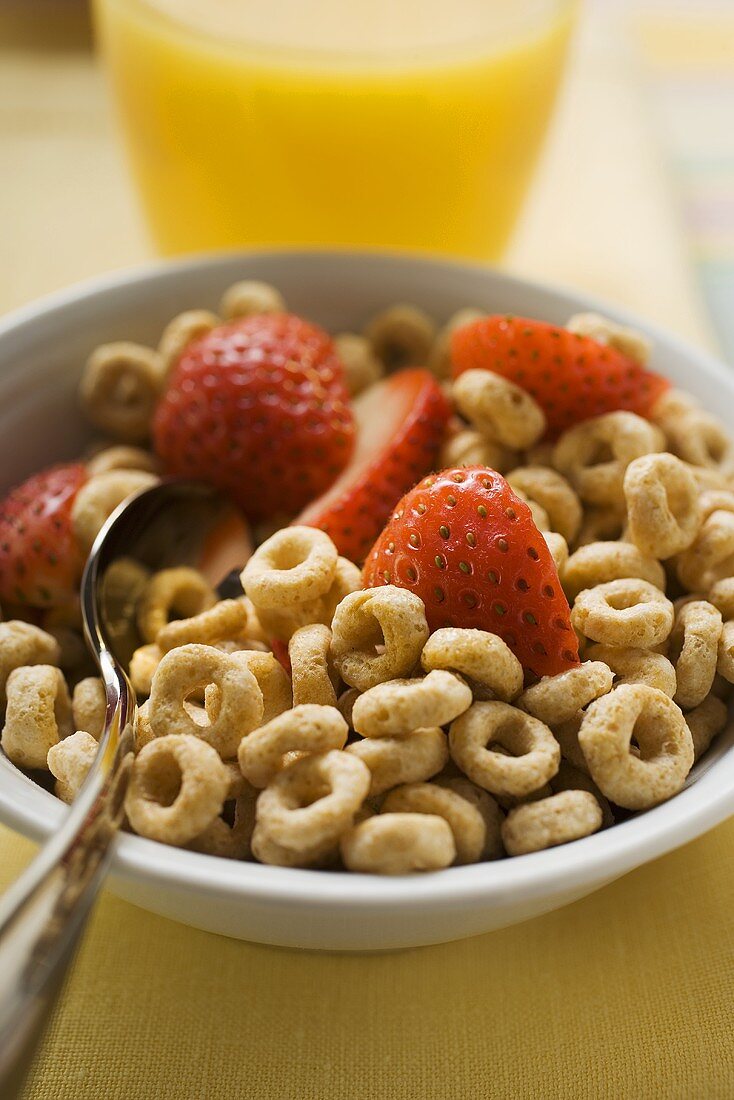 Breakfast cereal rings and strawberry halves in a bowl