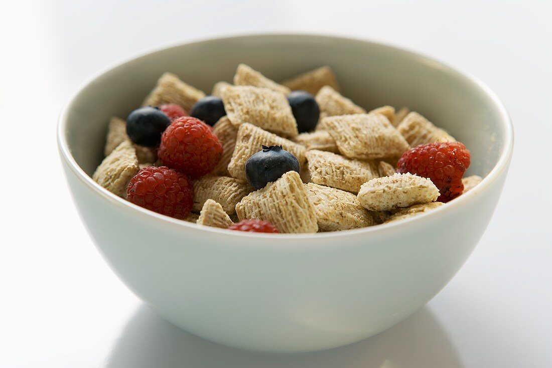Shredded wheat cereal and berries in a cereal bowl