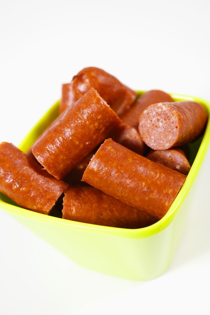 Pieces of Debreziner sausage in plastic bowl