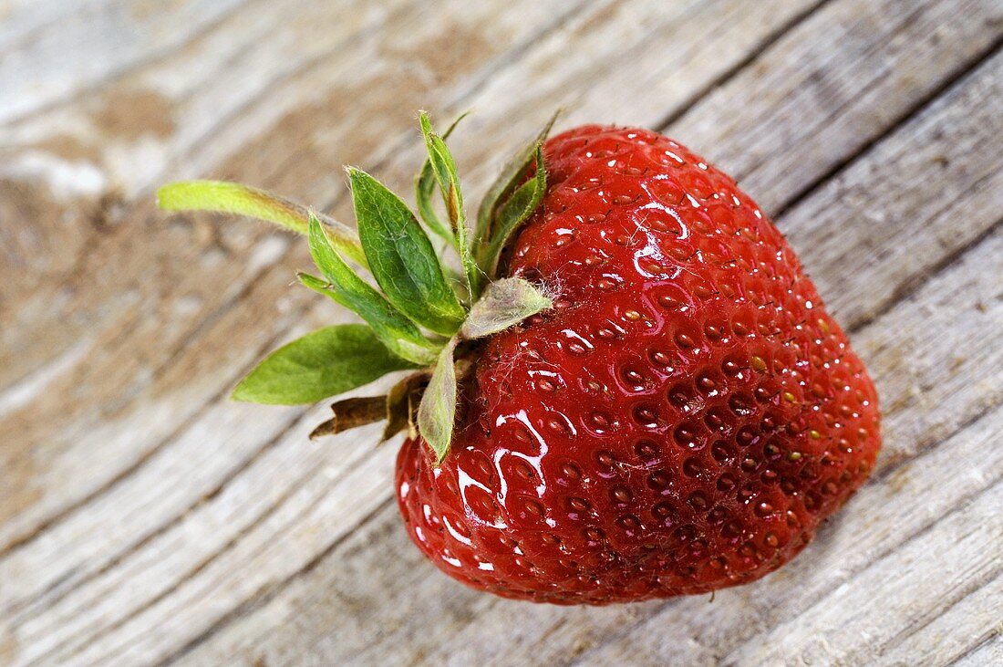 A strawberry on a wooden background